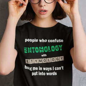 Pu&ograve; includere: T-shirt unisex nero con la scritta "people who confuse ENTOMOLOGY with ETYMOLOGY bug me in ways I can't put into words." La tabella delle taglie mostra le misure in pollici. T-shirt Gildan 64000 Unisex Softstyle.