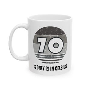 White ceramic mug featuring a vintage-style circular graphic with the number “70” and the text “Is only 21 in Celsius” in black lettering.