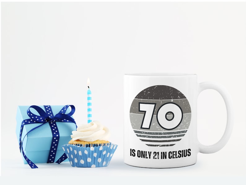 A white 11-ounce ceramic mug with a comfortable C-handle and rounded edges. The black and white design displays the words 70 Is Only 21 in Celsius.