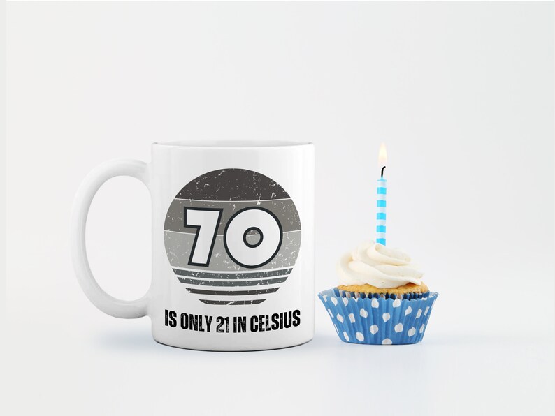 A white 11-ounce ceramic mug with a comfortable C-handle and rounded edges. The black and white design displays the words 70 Is Only 21 in Celsius.
