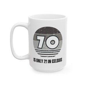 White ceramic mug featuring a vintage-style circular graphic with the number “70” and the text “Is only 21 in Celsius” in black lettering.