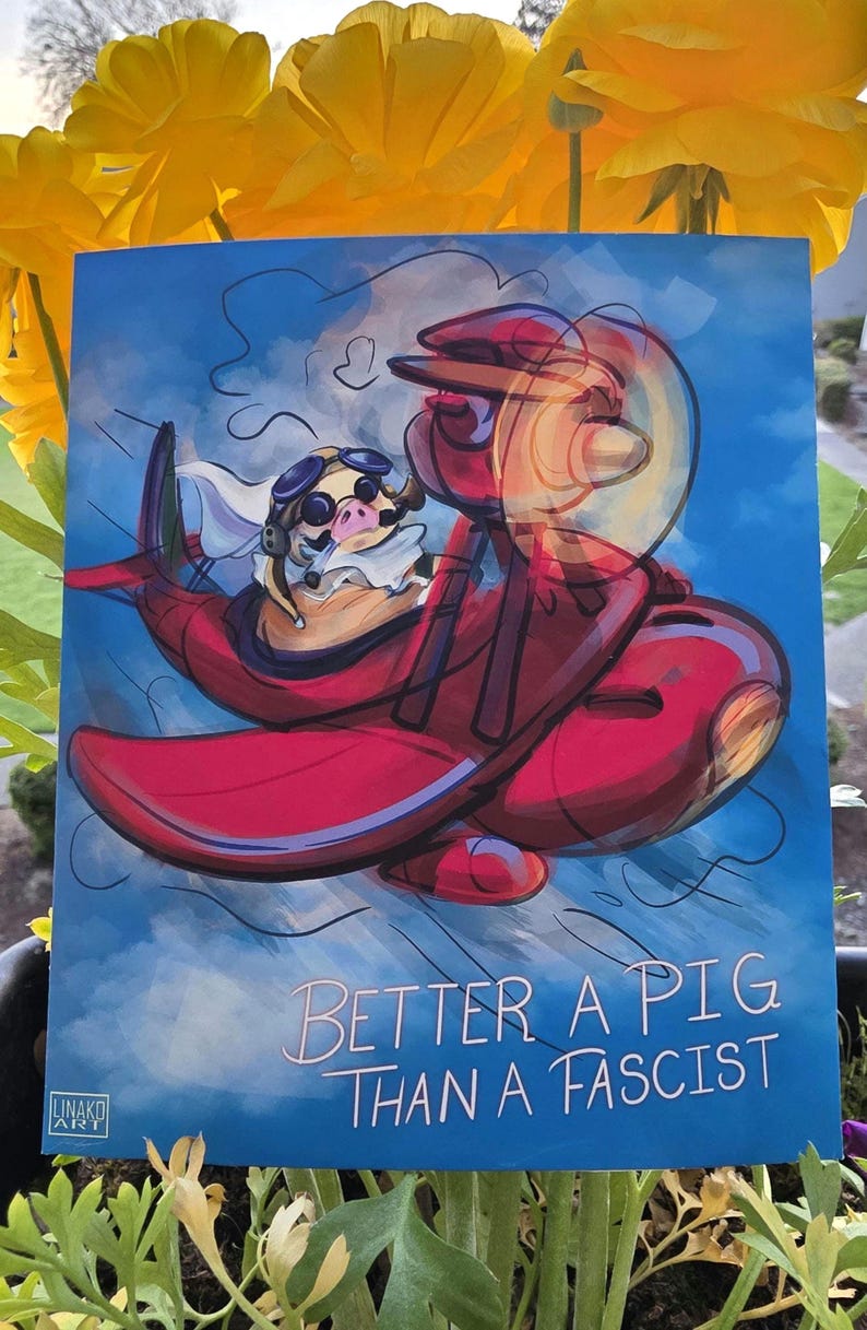 May include: A blue print featuring a pig in a red airplane with the text "Better a Pig Than a Fascist." The pig wears goggles and a scarf. The artwork is set against a blue sky with white clouds.