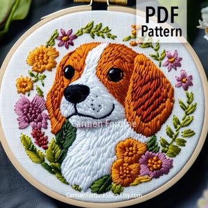Puede incluir: Arte de aro bordado con un perro beagle de pelaje naranja y blanco, rodeado por una corona floral de flores naranjas, rosas y verdes. El texto "PDF Pattern" se muestra en la parte superior. El nombre del artista y la URL de la tienda están en la parte inferior.