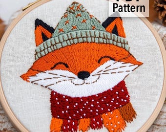 Könnte beinhalten: Gestickter Fuchs mit grüner Mütze und rotem Schal mit weißen Punkten in einem Holzreifen. Der Fuchs lächelt. Der Text "PDF Pattern" befindet sich oben rechts. Der Etsy-Shop-Name steht unten.