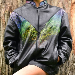 May include: A black leather jacket with a colorful abstract design on the front. The jacket has a zipper closure and a stand-up collar.