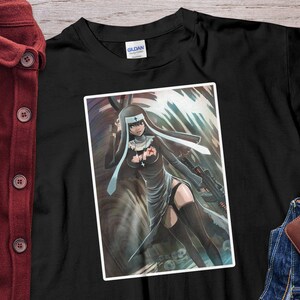 May include: Black t-shirt featuring a graphic of a nun holding a rifle. The illustration is in a comic book style with a dark color palette. The shirt is made of a soft material and has a crew neck.
