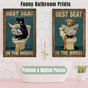 May include: Two vintage-style bathroom posters with a blue background and a brown wooden frame. The posters feature a black cat and a brown dog sitting on a toilet and reading a newspaper. The text on the posters reads "Best Seat in the House".