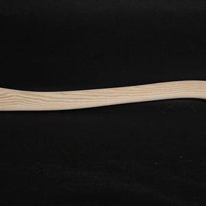 Puede incluir: Un mango de hacha de madera marrón claro con forma curva.