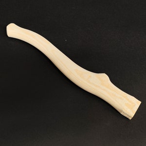 May include: A natural wood axe handle with a slightly curved shape. The handle is unfinished and has a smooth surface.