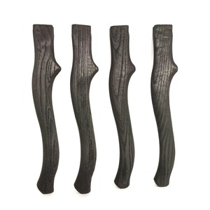 Op de afbeelding: Vier zwarte houten handvatten met een gebogen vorm en een getextureerd oppervlak.