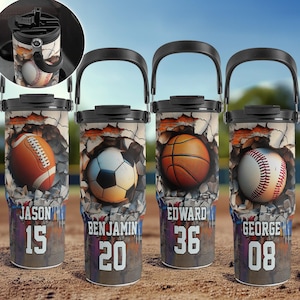 May include: Four stainless steel travel mugs with different sports ball designs and names. The mugs have a black handle and lid. The designs include a football, soccer ball, basketball, and baseball. The names on the mugs are Jason 15, Benjamin 20, Edward 36, and George 08.