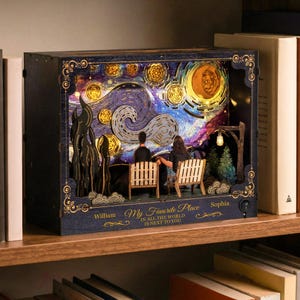 May include: A wooden, illuminated diorama depicting a couple seated on a bench under a starry night sky, reminiscent of Van Gogh's style. The diorama includes the text "My Favorite Place" and names "William" and "Sophia".