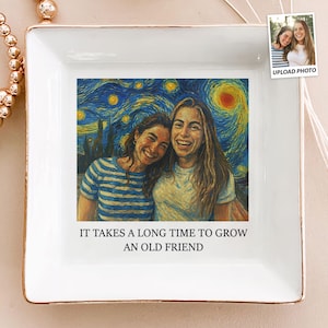 May include: White square trinket tray with gold trim, featuring a photo of two smiling people against a Van Gogh "Starry Night" backdrop. The text "IT TAKES A LONG TIME TO GROW AN OLD FRIEND" is printed below the image. A small photo is in the upper right corner.