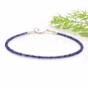 Può includere: Un braccialetto delicato in argento con piccole perle rotonde di pietre preziose blu.