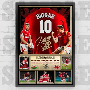 Può includere: Un poster incorniciato con una maglia da rugby rossa con il nome "BIGGAR" e il numero "10" sul retro. La maglia è firmata da Dan Biggar, un giocatore di rugby gallese. Il poster include anche una foto di Biggar in azione, insieme alle sue statistiche per il Galles e i British & Irish Lions.