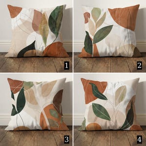 Op de afbeelding: Vier vierkante sierkussens met abstracte botanische ontwerpen. Elk kussen heeft een witte achtergrond met een unieke opstelling van bladeren en organische vormen in tinten bruin, groen en beige. De kussens worden gepresenteerd op een houten oppervlak.