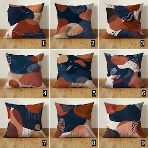 Könnte beinhalten: Neun quadratische Zierkissen mit abstrakten Designs. Jedes Kissen hat ein einzigartiges Muster aus organischen Formen in Marineblau, Rost, Beige und Weiß. Die Kissen scheinen aus einem weichen Stoff zu sein.