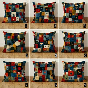Könnte beinhalten: Neun dekorative Zierkissen mit abstrakten geometrischen Designs. Jedes Kissen hat ein einzigartiges Patchwork aus Quadraten und Rechtecken in Blau-, Rot-, Gelb- und Grüntönen. Die Kissen sind auf einer Holzoberfläche angeordnet.