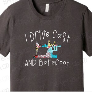 May include: A dark gray t-shirt with the text "I Drive Fast And Barefoot" in white. A colorful patchwork sewing machine graphic is above the text.