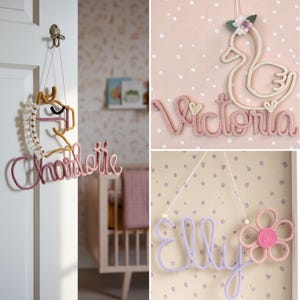 May include: Three wall-hanging name signs made of knitted yarn. One features a gold horse and the name Charlotte in pink. Another shows a white swan with a flower and the name Victoria in pink. The third displays the name Elly in purple with a flower.