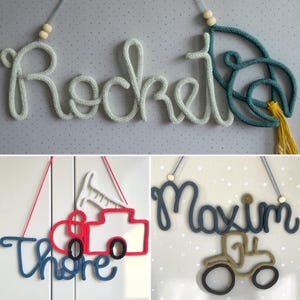 May include: Three wall-hanging signs made of knitted yarn cord. One sign spells Rocket in light blue with a teal rocket ship. Another spells Thore in blue with a red fire truck. The third spells Maxim in dark blue with a tan tractor.