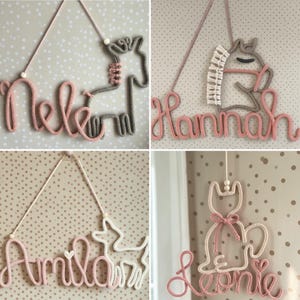 May include: Four wall hangings made of knitted cord shaped into names and animal outlines. The designs include the names Nele, Hannah, Amila, and Leonie, paired with shapes of a horse, a pony, a deer, and a cat in pink, white, and grey tones.