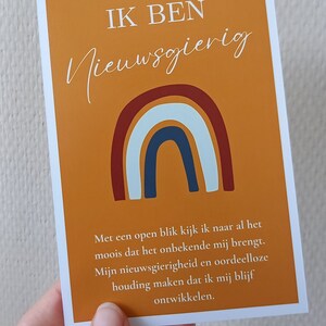 May include: A motivational quote card with a rainbow design and the text "IK BEN Nieuwsgierig". The text below the rainbow reads "Met een open blik kijk ik naar al het moois dat het onbekende mij brengt. Mijn nieuwsgierigheid en oordeelloze houding maken dat ik mij blijf ontwikkelen."