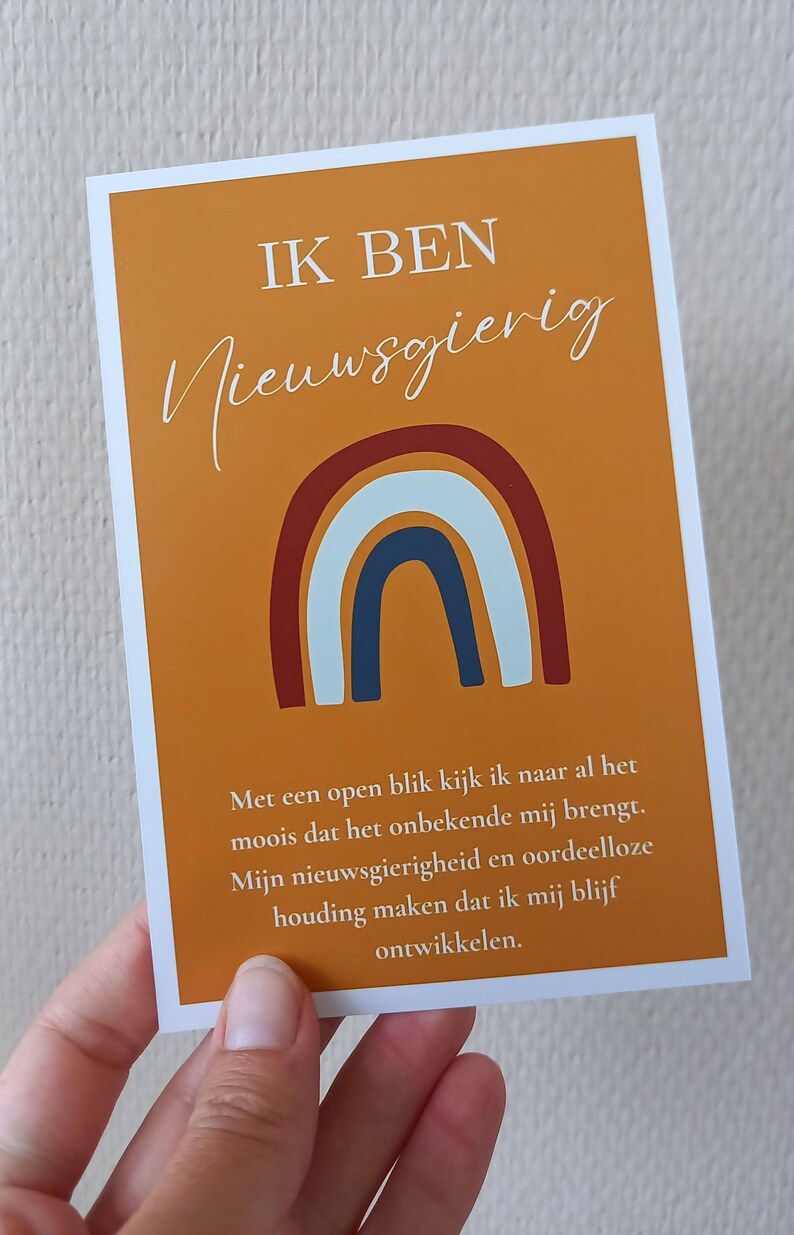 May include: A motivational quote card with a rainbow design and the text "IK BEN Nieuwsgierig". The text below the rainbow reads "Met een open blik kijk ik naar al het moois dat het onbekende mij brengt. Mijn nieuwsgierigheid en oordeelloze houding maken dat ik mij blijf ontwikkelen."