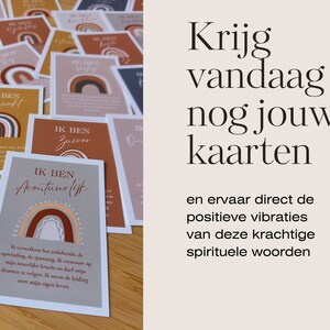 May include: A stack of colourful affirmation cards with rainbow designs and inspirational messages in Dutch. The cards feature phrases like "Ik ben avontuurlijk" and "Ik ben zuiver". The text on the cards reads "Krijg vandaag nog jouw kaarten en ervaar direct de positieve vibraties van deze krachtige spirituele woorden."