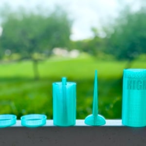 May include: A set of five teal 3D printed objects including two small rings, a cylindrical container with a central post, a triangular fin-like piece, and a larger cylindrical container with the word HIGH embossed on the side surface.