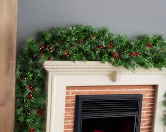 May include: A green artificial pine garland draped over a fireplace mantel, decorated with small red berries, brown pinecones, and tiny warm white string lights that illuminate the lush, needle-like foliage along the fireplace edge.