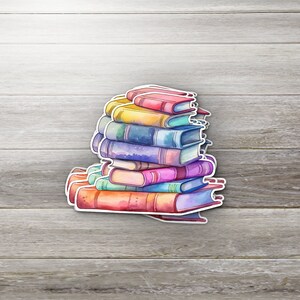 May include: A stack of colorful books with watercolor painted covers. The books are arranged in a pile with the spines facing out. The books are a variety of sizes and shapes.