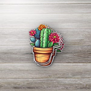 Könnte beinhalten: Eine Cartoon-Illustration eines Topfkakteen mit grünen, blauen und roten Blüten. Der Kaktus steht in einem braunen Topf mit weißem Rand.