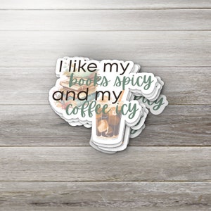 May include: A sticker with the text "I like my books spicy and my coffee icy" with a stack of books and a glass of iced coffee.