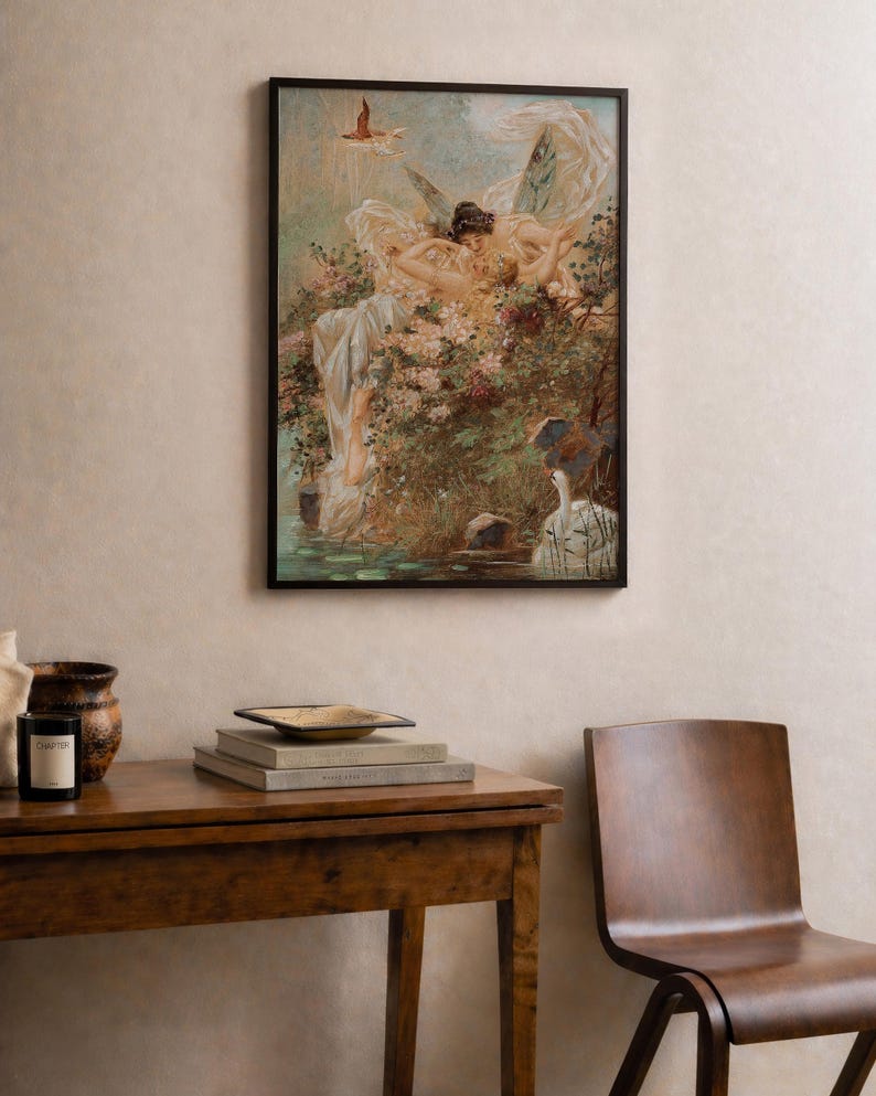 May include: A framed wall art print featuring a painting of two winged figures resting amidst lush flowers and greenery near a body of water with a white swan. The artwork displays soft pastel tones, intricate details of foliage, and a bird in flight.