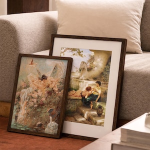 May include: Two rectangular framed art prints featuring classical paintings. The left print depicts winged figures amidst flowers and water. The right print shows two people sitting on stone steps near a white horse statue and a decorative urn.