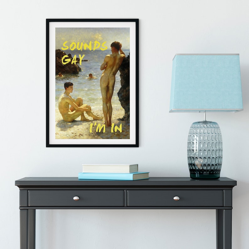 Pode incluir: Uma impress&atilde;o emoldurada de uma pintura que retrata dois homens em p&eacute; numa praia. Os homens est&atilde;o nus e a pintura &eacute; de estilo realista. O texto "SOUNDS GAY I'M IN" est&aacute; escrito em amarelo na impress&atilde;o.