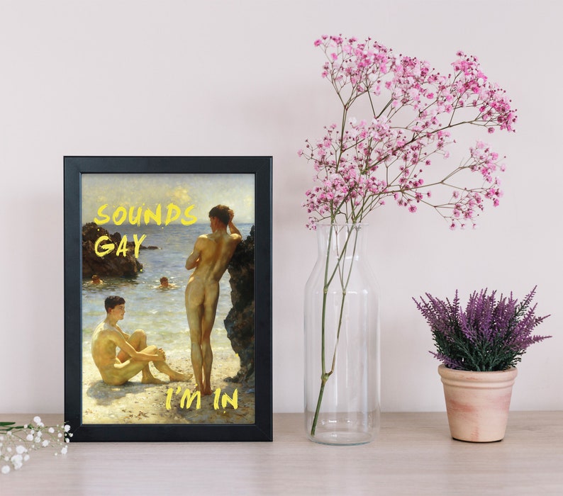 Pode incluir: Uma impress&atilde;o emoldurada de uma pintura que retrata dois homens nus em p&eacute; numa praia. A pintura &eacute; intitulada "Sounds Gay I'm In".