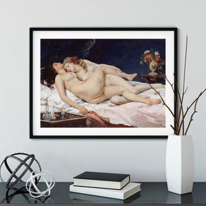 May include: A framed art print depicting a classical oil painting of two figures lying together on a bed with white linens. The scene includes a dark blue background, a small table with a blue glass decanter, and a vase of flowers on a side table.