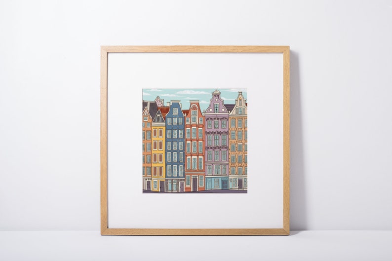 Pu&ograve; includere: Un'illustrazione incorniciata di una fila di case colorate con diversi stili architettonici. Le case sono dipinte in tonalit&agrave; di giallo, blu, rosa e arancione, con finiture e finestre bianche. L'illustrazione &egrave; posizionata su uno sfondo di cielo azzurro con nuvole bianche.