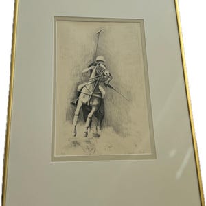 May include: A black and white framed print of a drawing of a person on horseback playing polo. The person is holding a mallet and the horse is rearing up. The print is signed "Walter Glo" in the bottom right corner.