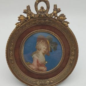 Puede incluir: Una taza de cerámica blanca con un asa negra y el texto "But First, Coffee" en un estilo manuscrito. La taza está sobre una superficie blanca. La taza mide aproximadamente 10 cm de alto.