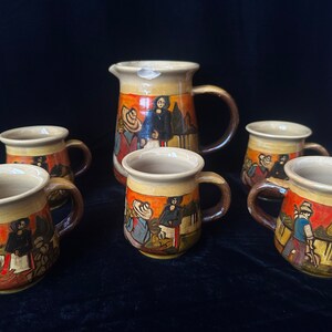 May include: Set of six ceramic mugs and a jug with hand-painted scenes of people in traditional clothing. The mugs and jug are in shades of brown, yellow, orange, and red.
