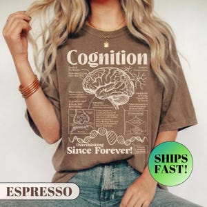 A model wearing a relaxed fit graphic t-shirt featuring a vintage anatomical diagram of a brain, synapses, and a DNA strand. The text reads Cognition and Overthinking Since Forever! with humorous scientific labels like Self-doubt Loop. A funny graphic tee for overthinkers and psychology lovers.