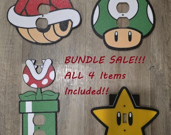 May include: Four decorative wall outlet covers featuring video game character designs: a red shell, a green mushroom, a piranha plant in a pipe, and a yellow star. The text BUNDLE SALE!!! ALL 4 Items Included!! is printed in the center of the image.