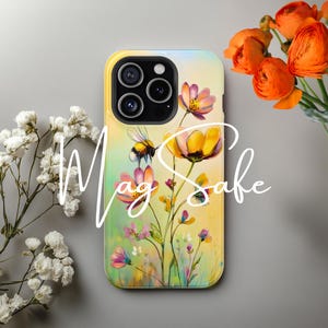 May include: A phone case with a floral design featuring yellow, pink, and white flowers with a bee on a green background.