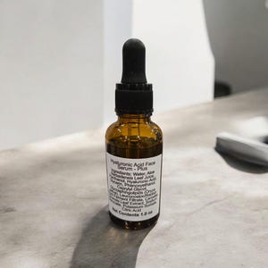 Peut inclure: Un flacon en verre brun avec un compte-gouttes noir. Le flacon contient du s&eacute;rum pour le visage &agrave; l'acide hyaluronique - Plus. L'&eacute;tiquette indique les ingr&eacute;dients&nbsp;: eau, jus de feuilles d'aloe vera, glyc&eacute;rine, ph&eacute;noxy&eacute;thanol, panth&eacute;nol, acide hyaluronique, caprylyl glycol, ferment de racine de radis/leuconostoc, extrait de feuille de cam&eacute;lia sinensis, st&eacute;arate de sodium, sorbate de potassium, acide citrique. Contenu net&nbsp;: 1,0&nbsp;oz.