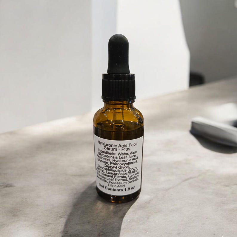 Peut inclure: Un flacon en verre brun avec un compte-gouttes noir. Le flacon contient du s&eacute;rum pour le visage &agrave; l'acide hyaluronique - Plus. L'&eacute;tiquette indique les ingr&eacute;dients&nbsp;: eau, jus de feuilles d'aloe vera, glyc&eacute;rine, ph&eacute;noxy&eacute;thanol, panth&eacute;nol, acide hyaluronique, caprylyl glycol, ferment de racine de radis/leuconostoc, extrait de feuille de cam&eacute;lia sinensis, st&eacute;arate de sodium, sorbate de potassium, acide citrique. Contenu net&nbsp;: 1,0&nbsp;oz.