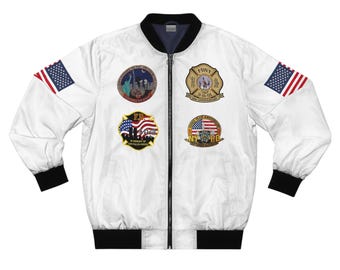 May include: White bomber jacket with black trim and a zip closure. The jacket has American flag patches on the sleeves and several embroidered patches on the chest, including FDNY and NYPD emblems, and a memorial design.