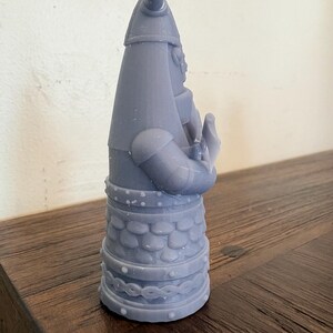 Op de afbeelding: Een lichtgrijs 3D-geprint beeldje van een krijger met een gehoornde helm en harnas. Het figuur heeft een conische helm, een borststuk met schubbenpatroon en een riem met een gevlochten ontwerp. De krijger is in profiel afgebeeld en houdt een voorwerp.